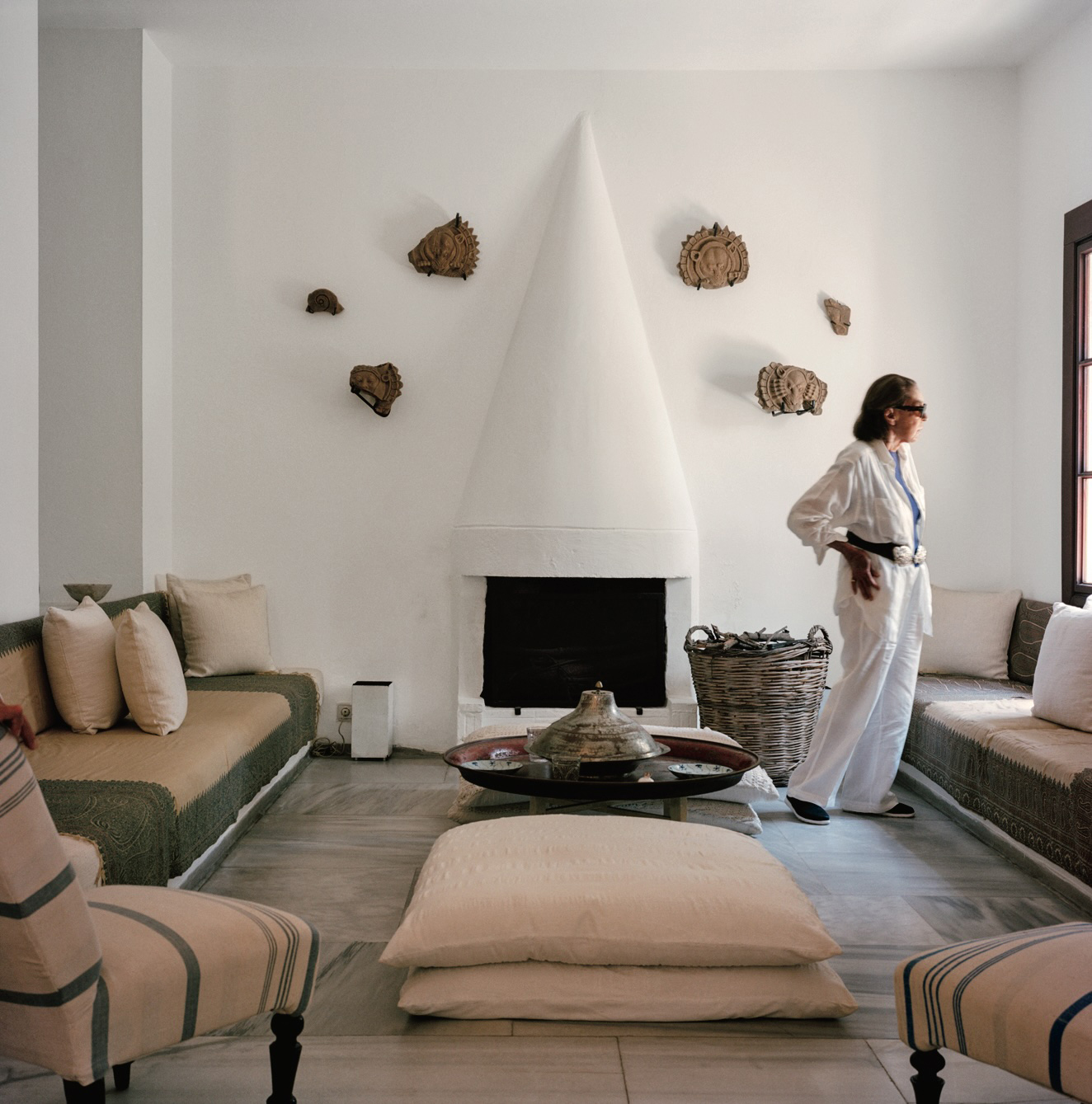A minimalist living room with a white conical fireplace and earth-toned decor.